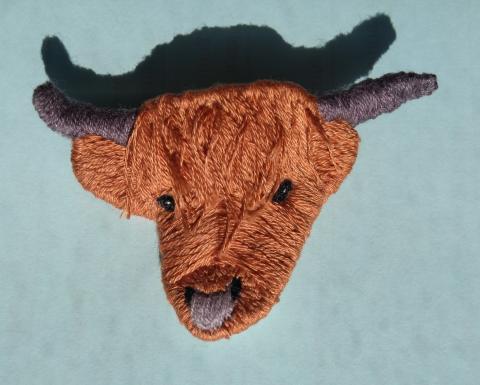 Embroidered head of a Highland cow