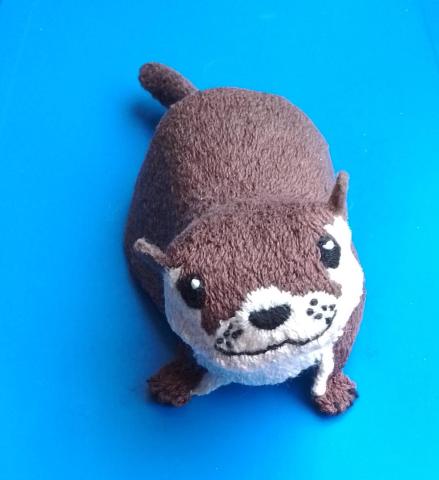 A cute otter stares up imploringly at the viewer. It probably wants fish.