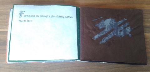 The two pages side by side, with the text on the left, embroidered onto a white page 